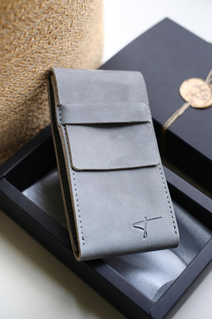 Gray suede watch pouch leaning against a black Talecraft box with a wax seal