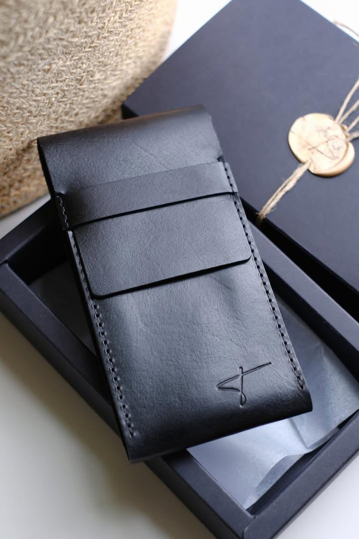 Black leather watch pouch leaning against a black Talecraft box with a wax seal