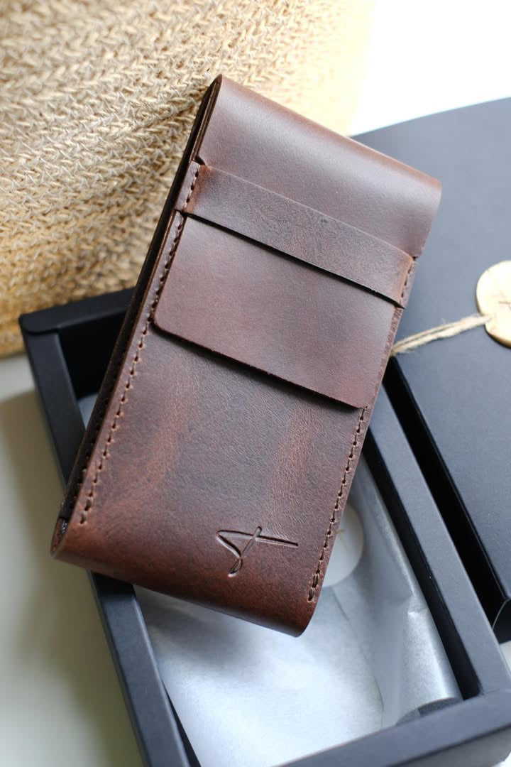 Brown leather watch pouch leaning against a black Talecraft box with a wax seal