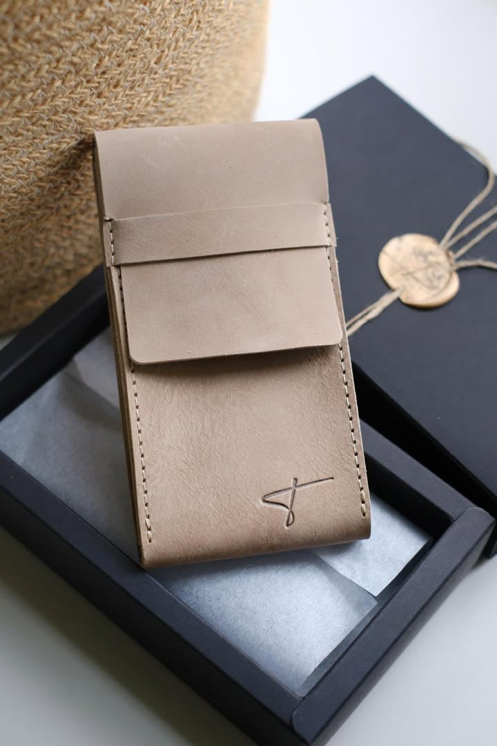 Beige suede watch pouch leaning against a black Talecraft box with a wax seal