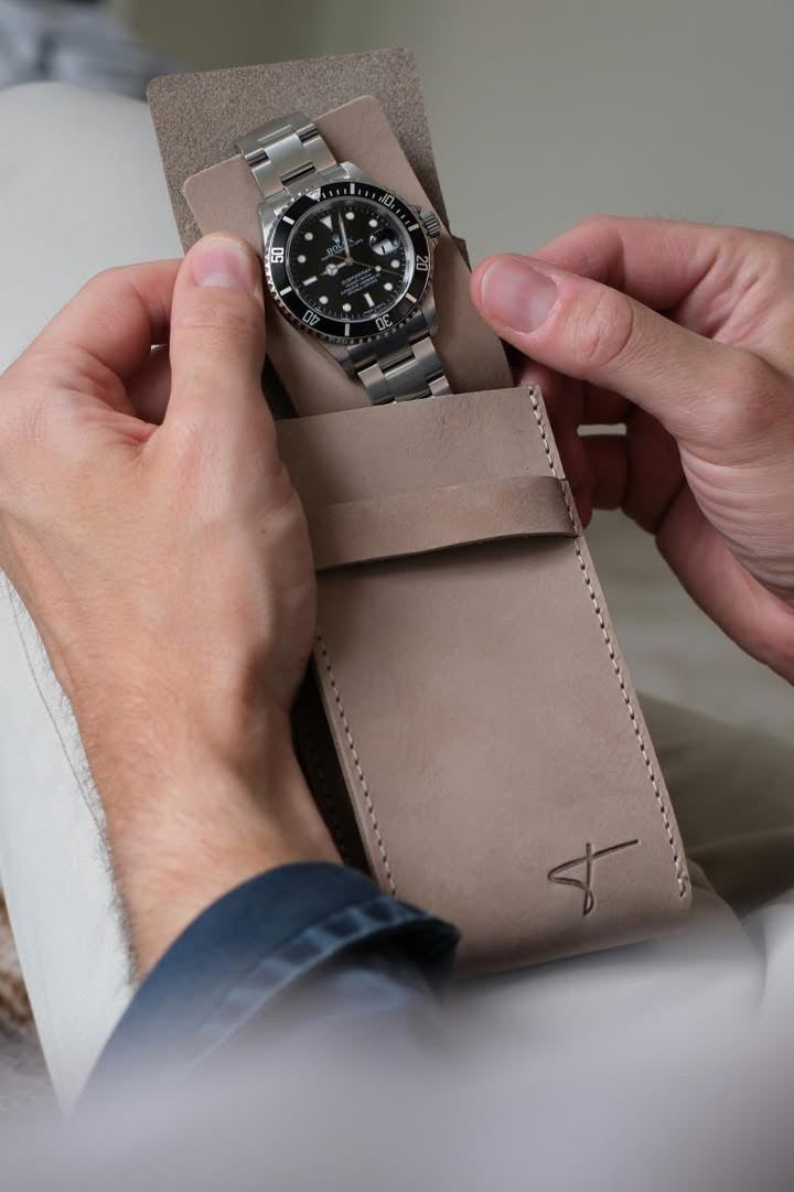 Beige suede watch pouch with a watch inside